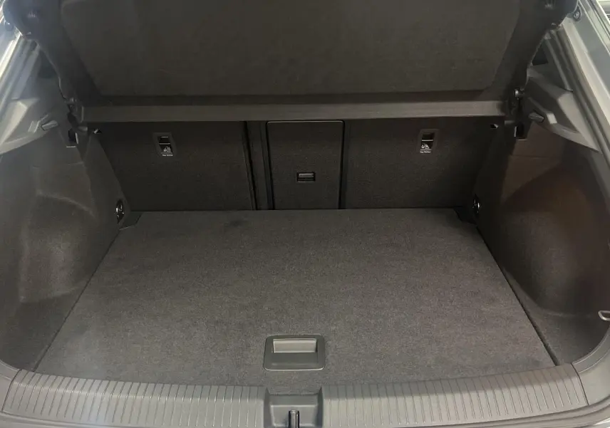 Coffre ouvert du Volkswagen T-Roc gris pyrite, montrant l'espace de chargement intérieur propre et spacieux.
