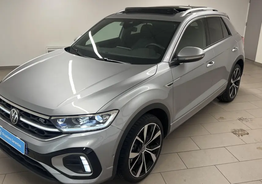 Vue 3/4 avant droit du Volkswagen T-Roc gris pyrite avec jantes 19 pouces Misano et toit ouvrant panoramique.