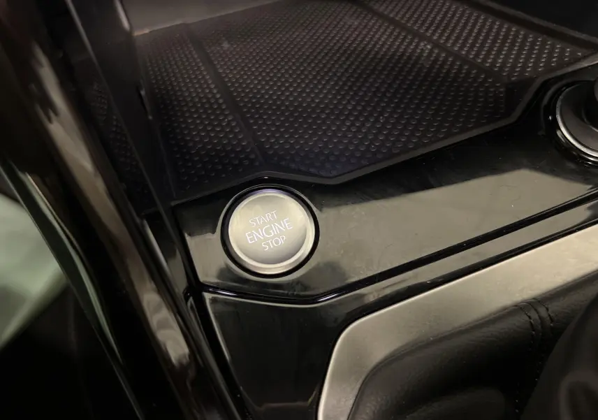 Bouton start/stop moteur sur la console centrale noire brillante du Volkswagen T-Roc 1.5 TSI 2024.