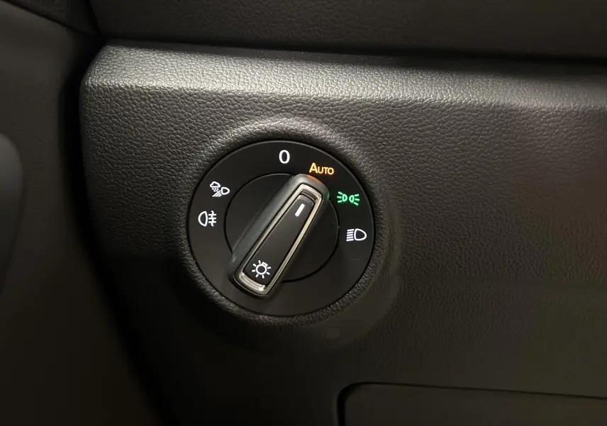 Gros plan sur la molette de commande des phares du Volkswagen T-Roc 2024, finition R-Line, intérieur noir.