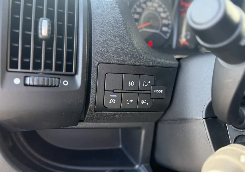 Détail des commandes d’éclairage et ventilation côté gauche du tableau de bord de l’Opel Movano Fourgon blanc 2023.
