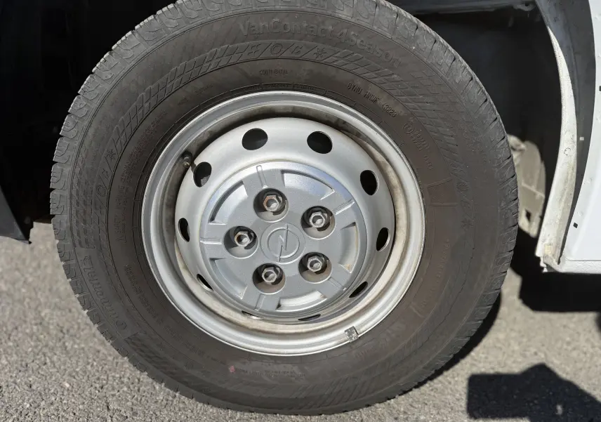 Gros plan sur la roue avant droite du fourgon blanc Opel Movano 2.2 BlueHDi 140 L3H2 avec jante acier et logo Opel au centre.