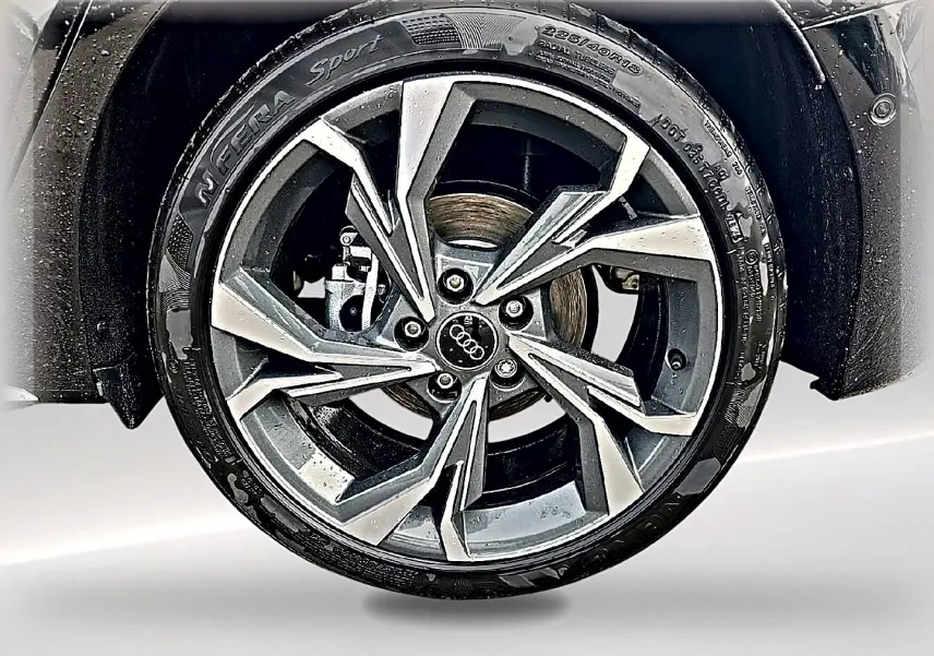 Gros plan sur la jante alu gris graphite à design sportif de l'Audi A3 Sportback noir Mythos.