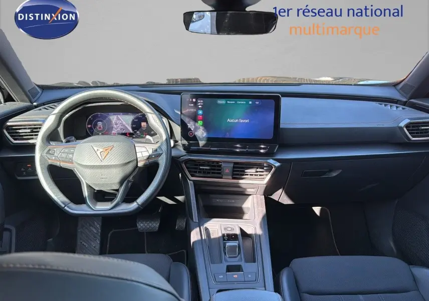Vue intérieure avant du CUPRA Formentor 1.4 E-HYBRID 2023, tableau de bord noir avec écran tactile central et volant multifonction.