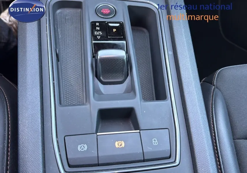 Vue rapprochée de la console centrale noire du CUPRA Formentor 1.4 E-HYBRID avec sélecteur de boîte automatique et boutons de contrôle.