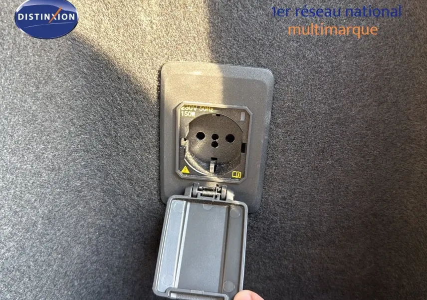 Prise de recharge hybride ouverte dans le coffre d’un CUPRA Formentor noir minuit, vue rapprochée.