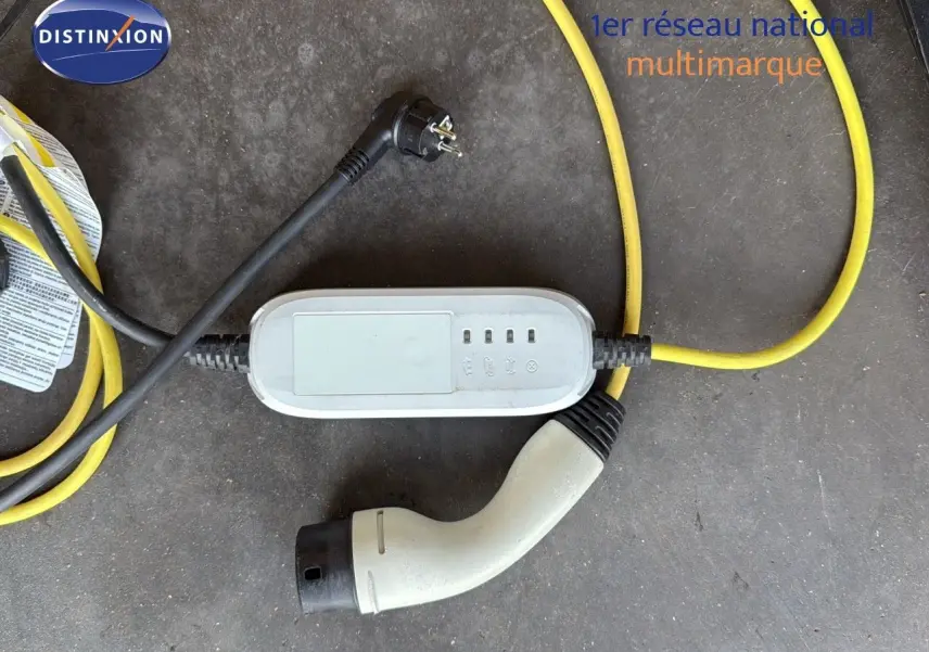 Vue rapprochée du câble de recharge hybride avec prise blanche et câble jaune sur sol gris, pour CUPRA Formentor noir 2023.