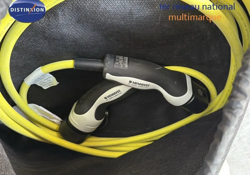 Gros plan sur câble de recharge jaune avec connecteurs Mennekes dans le coffre d'un CUPRA Formentor noir minuit hybride rechargeable.
