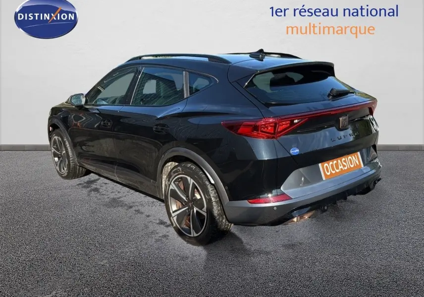 Vue 3/4 arrière droite d'une CUPRA Formentor noir minuit métal, avec jantes bi-ton et feux arrière allongés.