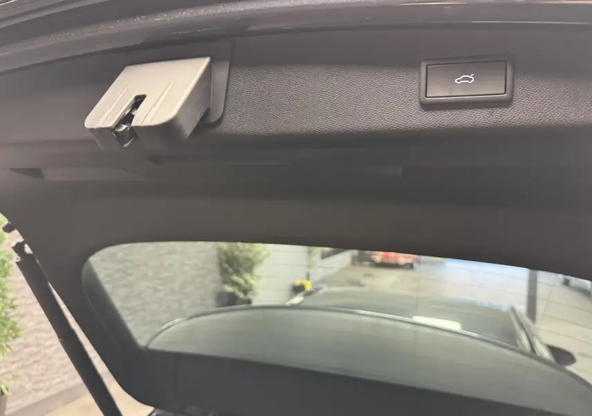 Vue intérieure du hayon ouvert de la CUPRA Leon Sportstourer gris, montrant le bouton d'ouverture électrique.