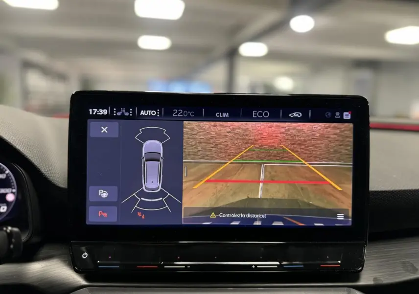 Écran tactile intérieur affichant la caméra de recul et l'aide au stationnement du CUPRA Leon Sportstourer gris 2024.