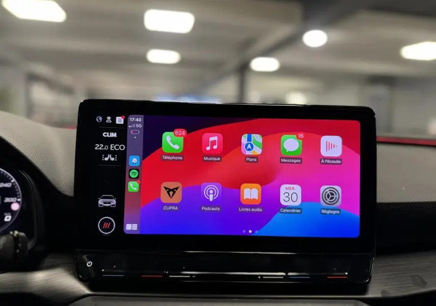Écran tactile central affichant l'interface Apple CarPlay dans l'habitacle d'une CUPRA Leon Sportstourer 2024.