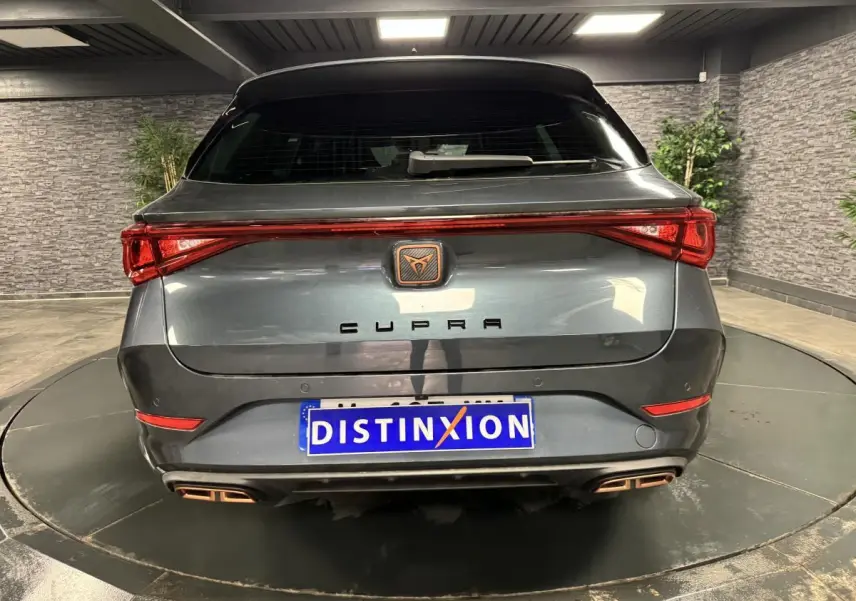 Vue arrière d'une CUPRA Leon Sportstourer gris magnétique avec feux LED et double sortie d'échappement cuivrée.