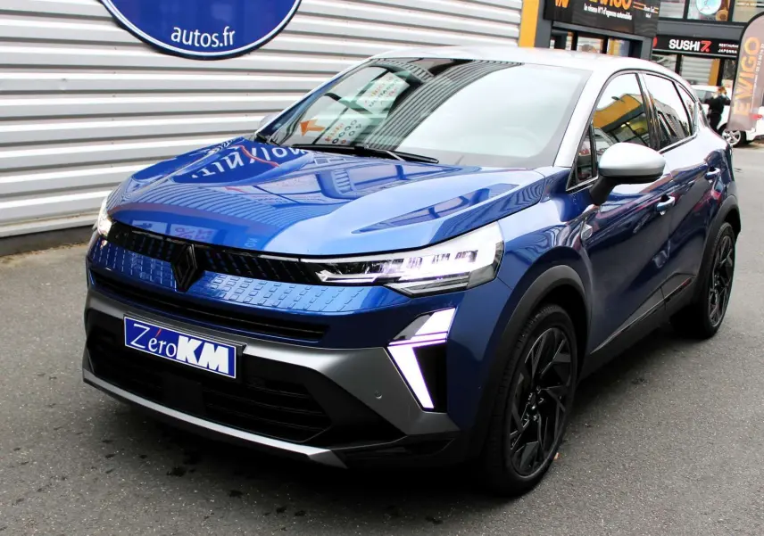 Renault Captur 2025 bleu Iron Metal avec toit gris, vue 3/4 avant mettant en valeur ses feux LED distinctifs.
