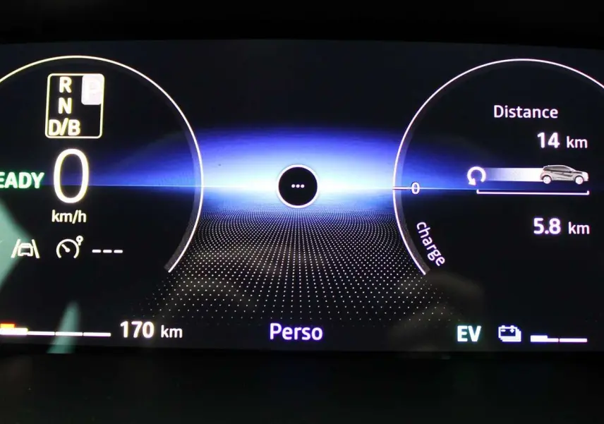 Tableau de bord numérique du Renault Captur 2025 affichant vitesse à 0 km/h, autonomie essence 170 km et mode hybride EV.