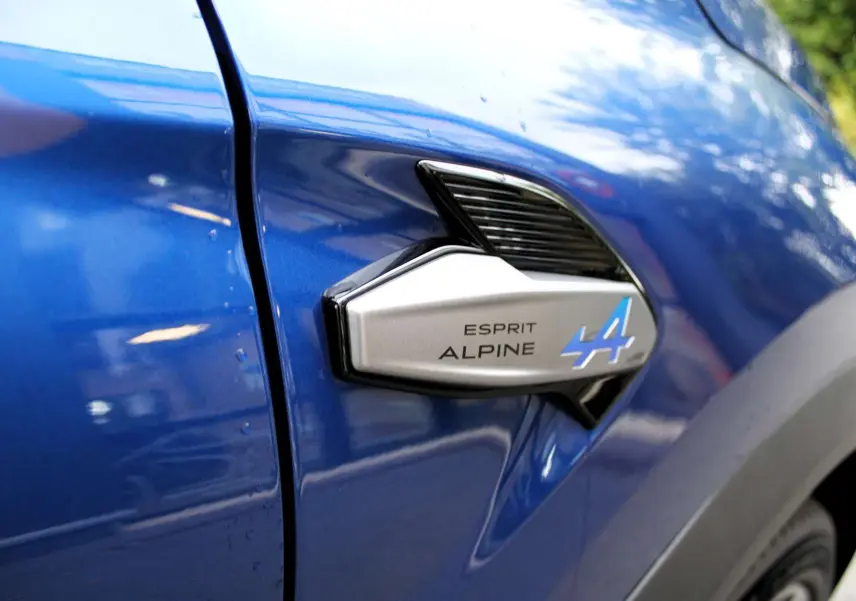Détail de l'insigne Esprit Alpine sur la portière côté gauche d'un Renault Captur bleu Iron Metal.