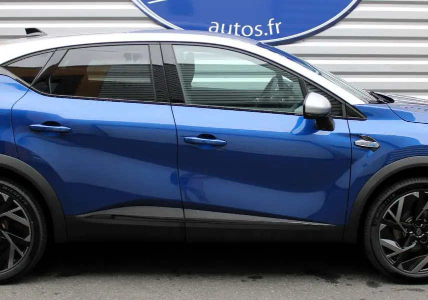 Profil côté gauche du Renault Captur 2025 bleu Iron Metal avec toit gris et jantes noires stylisées.