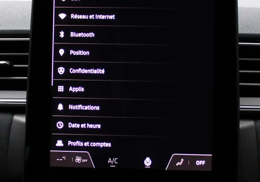 Écran tactile central du tableau de bord du Renault Captur 2025 avec menu paramètres et commandes climatisation.