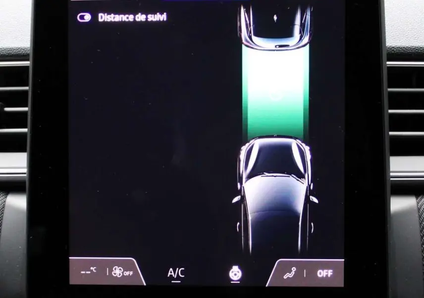 Écran tactile central du Renault Captur 2025 montrant l'aide à la conduite avec vue du véhicule en noir sur fond sombre.