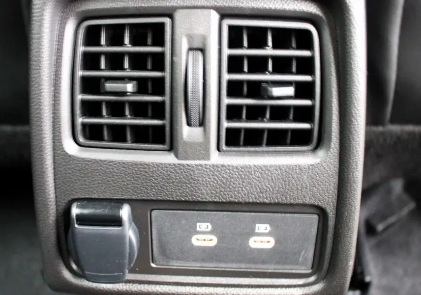 Gros plan sur la console arrière noire du Renault Captur 2025 avec deux bouches d'aération et ports USB visibles