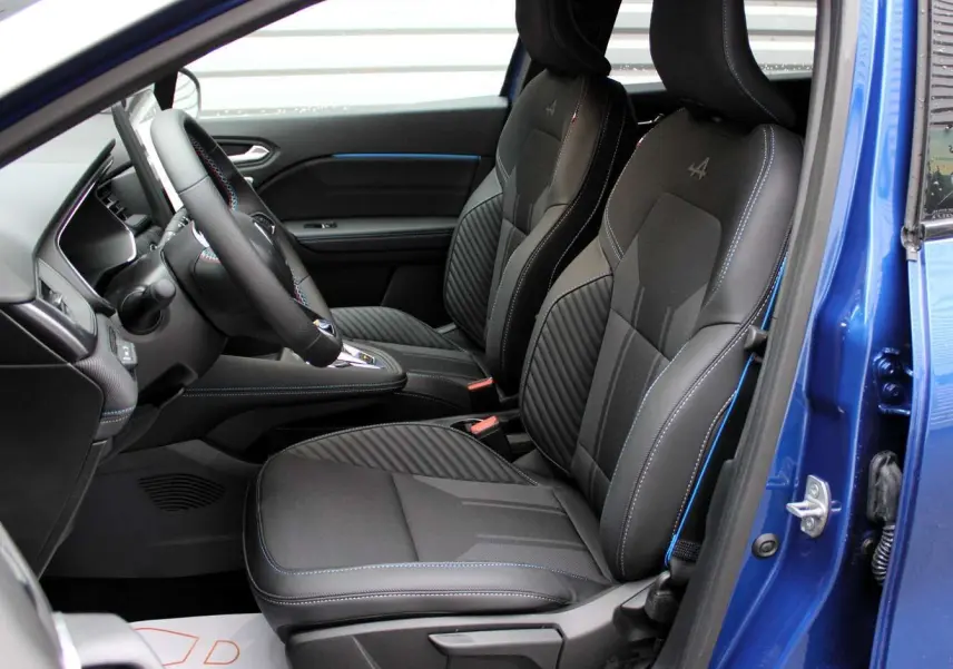 Vue intérieure côté gauche du Renault Captur 2025 bleu iron metal, sièges noirs avec surpiqûres bleues et logo Alpine brodé.