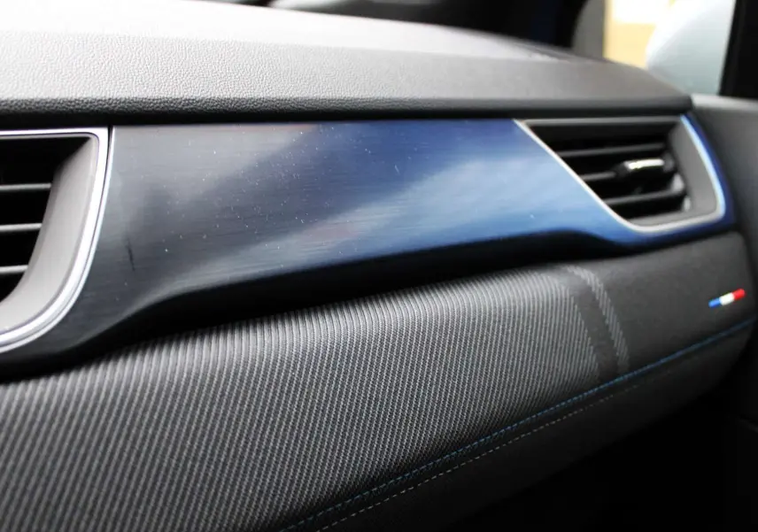 Détail de la planche de bord du Renault Captur 2025 avec insert bleu et surpiqûres bleues côté passager.