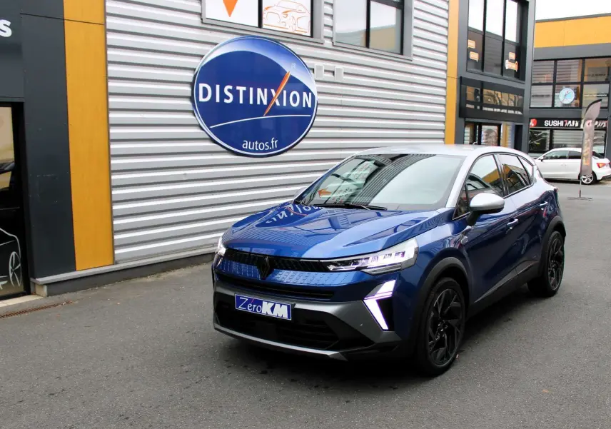 Renault Captur 2025 bleu Iron Metal avec toit gris, vue 3/4 avant droit, feux LED et jantes noires visibles.