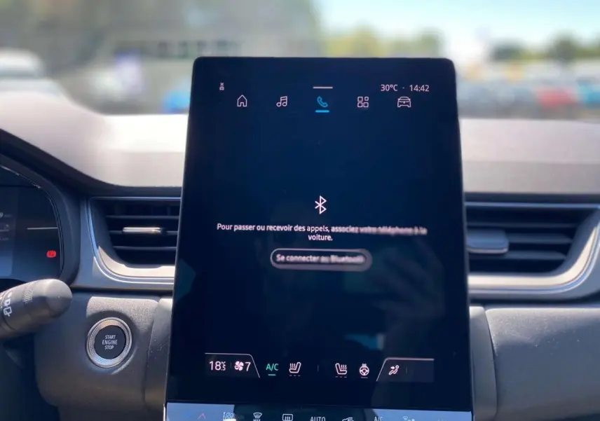 Vue rapprochée de l'écran tactile central du Renault Captur gris Cassiopée, affichant les commandes de climatisation et connectivité.