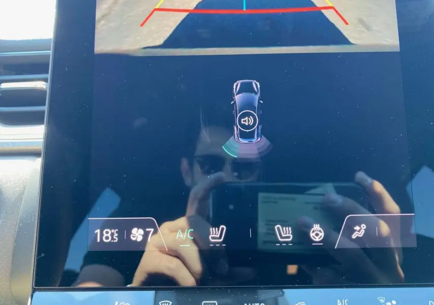 Écran tactile intérieur du Renault Captur 2025 montrant la caméra de recul et les commandes de climatisation et sièges chauffants.