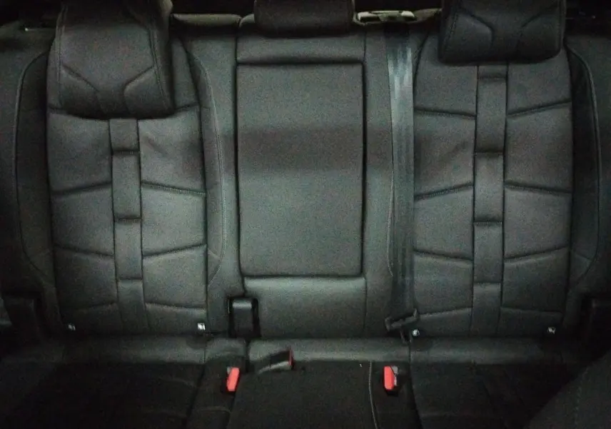 Vue rapprochée de la banquette arrière en cuir noir Basalte du DS7 2025, avec appuie-tête et ceintures visibles.