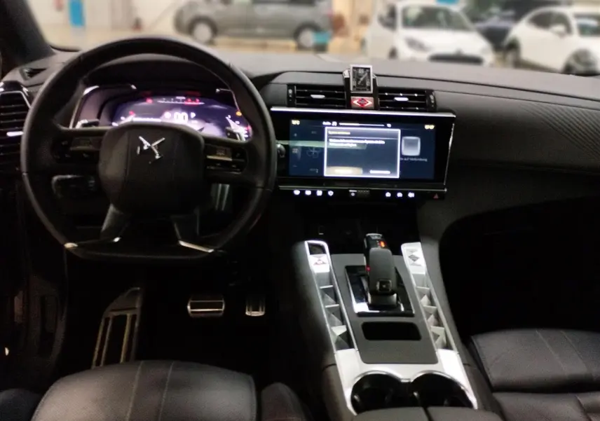 Vue intérieure du tableau de bord et console centrale du DS7 noir avec écran tactile et volant cuir noir.
