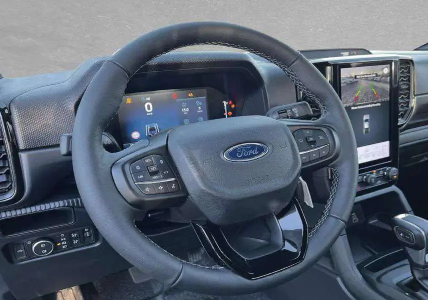 Vue rapprochée du volant cuir multifonctions et du tableau de bord numérique du Ford Ranger 2025.