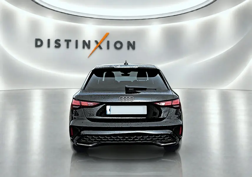 Vue arrière d'une Audi A3 Sportback noir mythos 2026 avec feux arrière LED et becquet intégré, en studio lumineux.