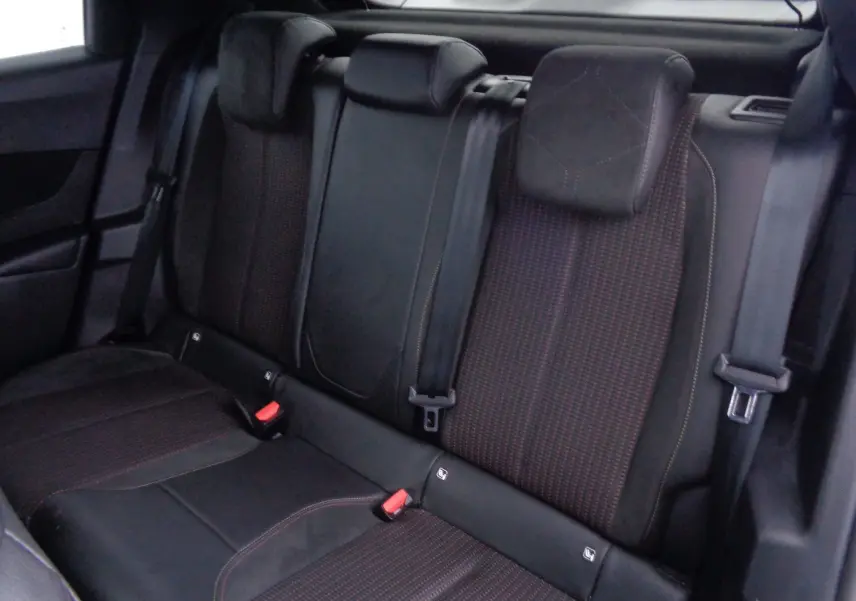 Vue rapprochée des sièges arrière en tissu noir et rouge du DS3 Crossback 2021, avec ceintures de sécurité visibles.