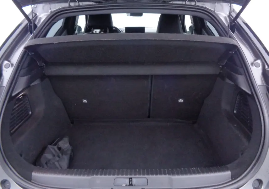 Vue arrière du coffre ouvert d'une DS3 Crossback gris platinium métal, montrant l'espace de chargement et la plage arrière relevée.