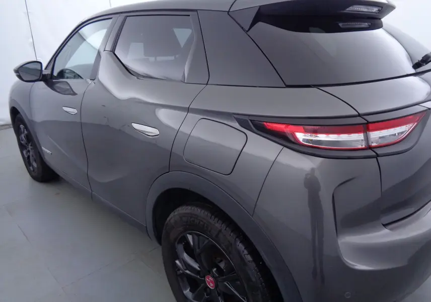 Vue 3/4 arrière droit du DS3 Crossback gris platinium métallisé, soulignant ses feux arrière LED et ses jantes noires.