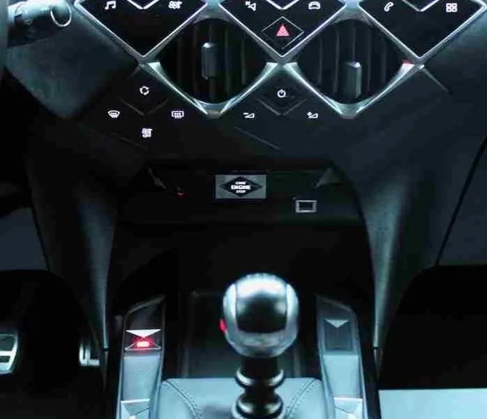 Vue intérieure centrée sur la console centrale noire du DS3 Crossback 2021 avec levier de vitesse manuel et écran tactile.