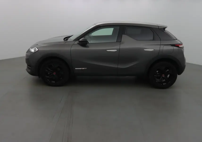 Profil côté gauche du DS3 Crossback gris platinium métallisé avec jantes noires et lignes sculptées visibles.