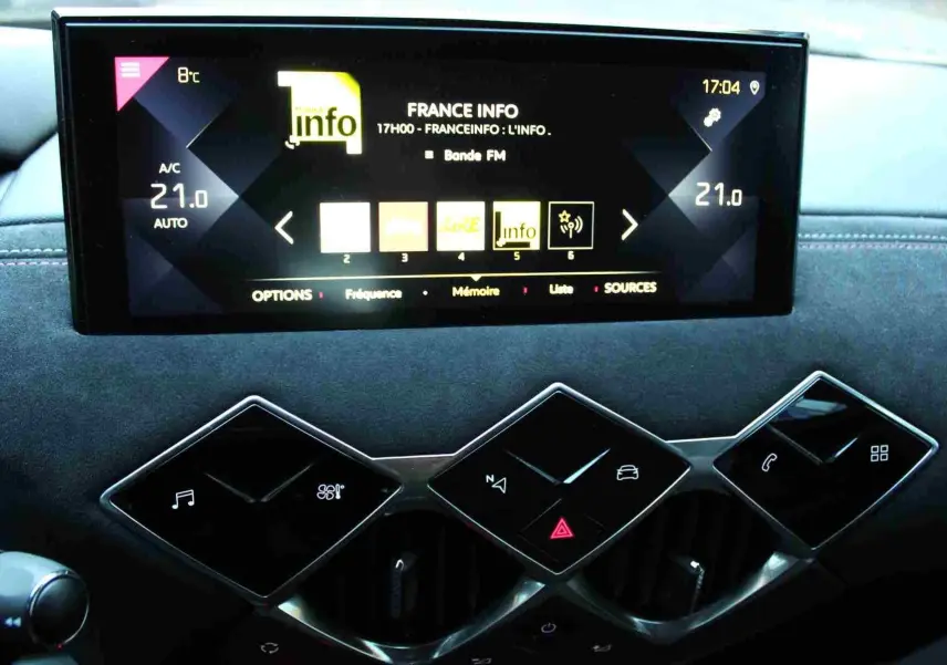 Vue rapprochée de la console centrale du DS3 Crossback 2021, avec écran tactile et commandes en losange sur finition gris platinium.