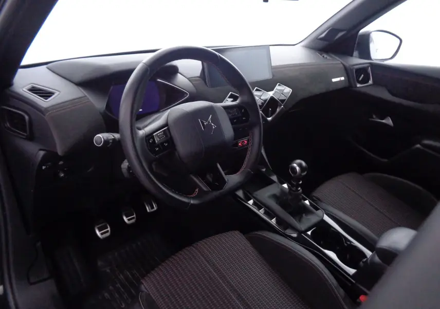 Vue intérieure côté conducteur du DS3 Crossback 2021, volant cuir noir, console centrale avec levier de vitesses manuel.