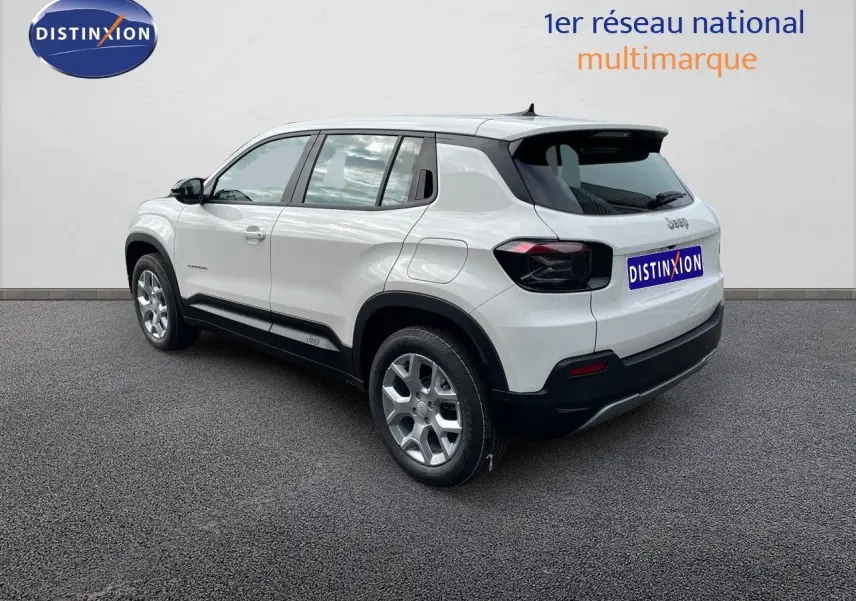 Jeep Avenger blanc neige vu de trois quarts arrière droit, avec jantes argentées et feux arrière noirs.