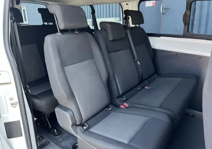 Vue intérieure côté droit sur les sièges tissu gris clair du Toyota Proace Fourgon blanc version 9 places.