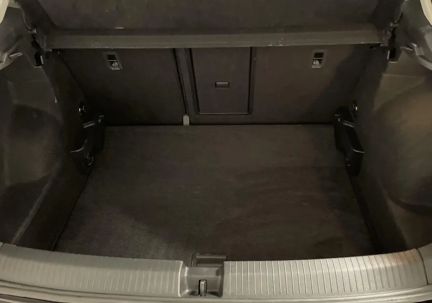 Coffre ouvert du Volkswagen T-Roc noir intense nacré, montrant l'espace de chargement intérieur vide et propre.