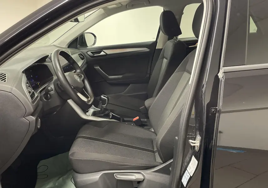 Vue intérieure côté conducteur du Volkswagen T-Roc noir intense nacré, mettant en valeur les sièges et le tableau de bord.