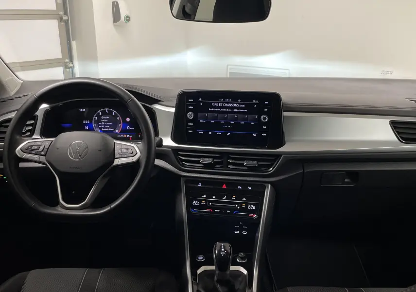Vue intérieure frontale du tableau de bord du Volkswagen T-Roc 2024 avec écran tactile et volant multifonctions.