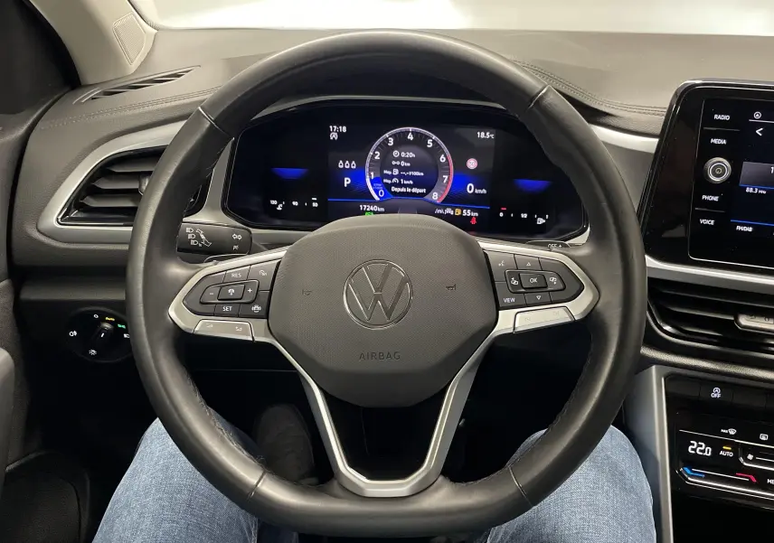 Volant en cuir noir et tableau de bord numérique du Volkswagen T-Roc 2024, affichage central et commandes au volant visibles.