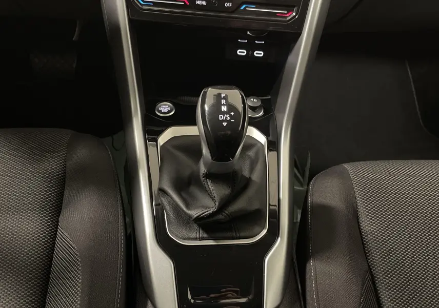 Le levier de vitesse automatique noir du Volkswagen T-Roc 2024, vu de dessus entre les sièges avant.