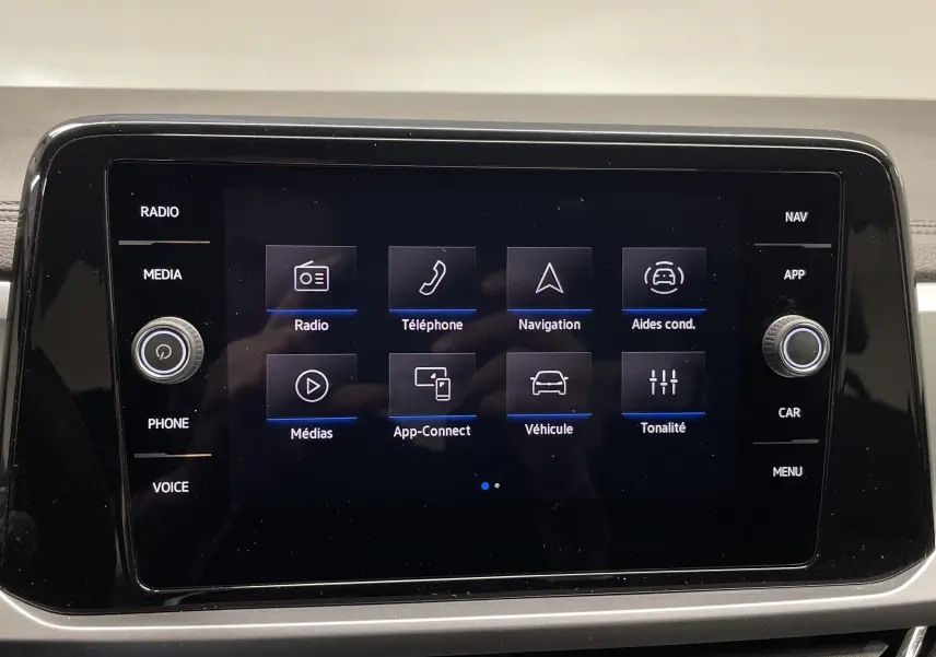 Écran tactile central du Volkswagen T-Roc 2024 affichant les options radio, navigation et aides à la conduite.