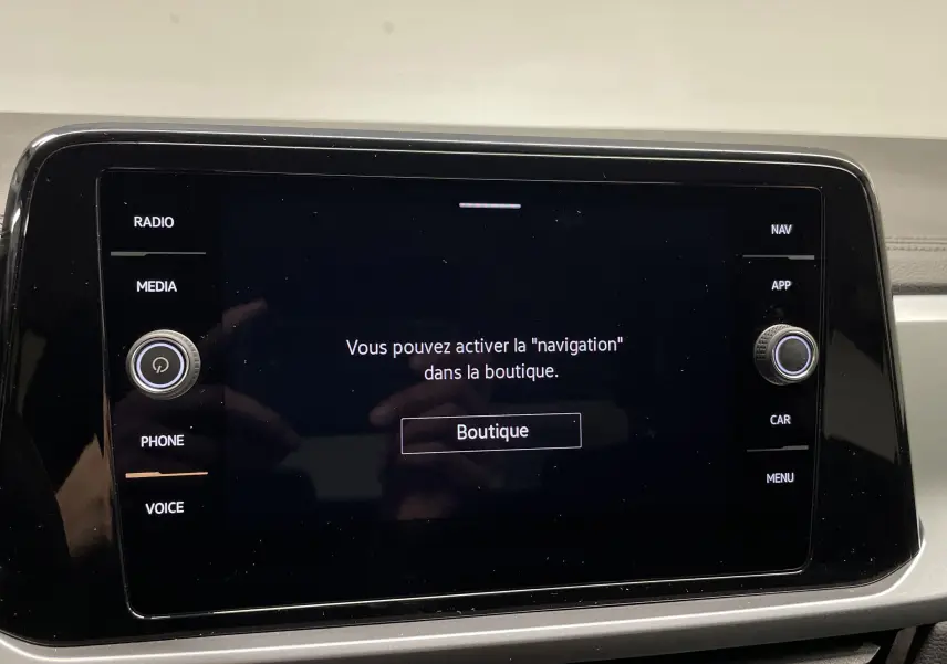 Écran tactile central du Volkswagen T-Roc 2024 affichant un message d'activation de navigation, intérieur gris clair.