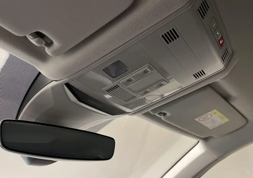 Vue intérieure du rétroviseur et plafonnier du Volkswagen T-Roc 2024 avec commandes intégrées et finition claire.